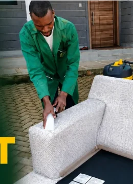 D-LUXE team member cleaning a sofa